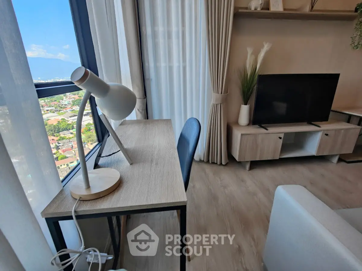 Modern living room with stylish desk, lamp, and TV, featuring a stunning city view through large windows.