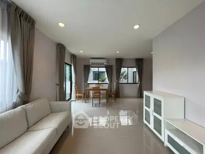 Spacious living room with modern furniture and large windows offering natural light.