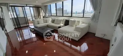 Spacious living room with panoramic city views and elegant hardwood floors.