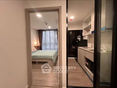 Modern studio apartment with cozy bedroom and compact kitchen, perfect for urban living.