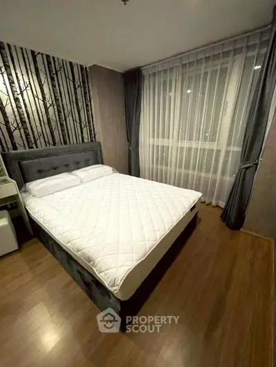 Cozy bedroom with stylish decor and large window for natural light