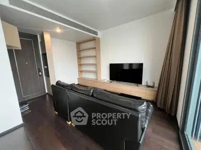 Modern living room with sleek black leather sofa and flat-screen TV