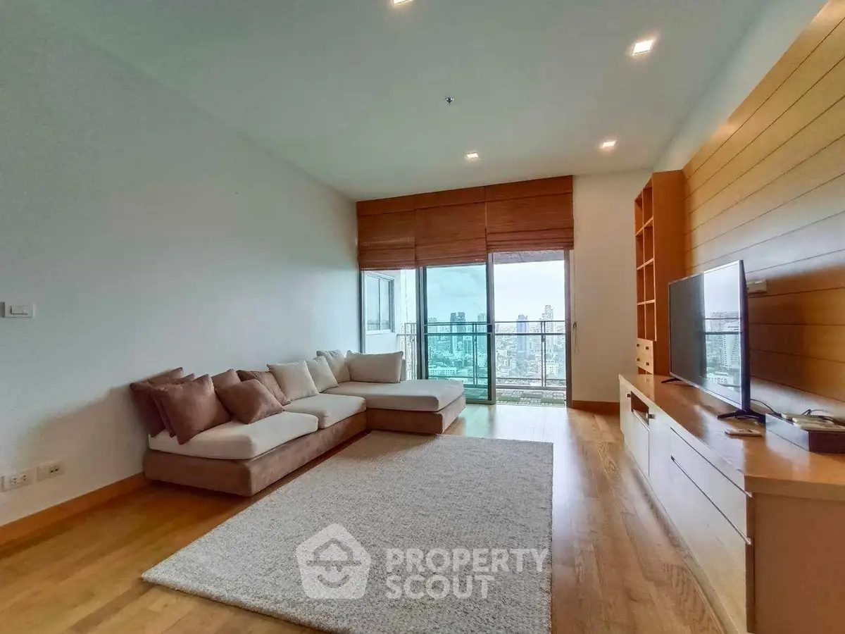 Spacious living room with modern decor and city view balcony in luxury apartment.