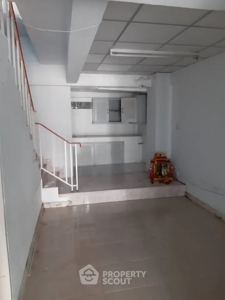 Spacious interior with staircase and kitchen area, ideal for renovation or customization.