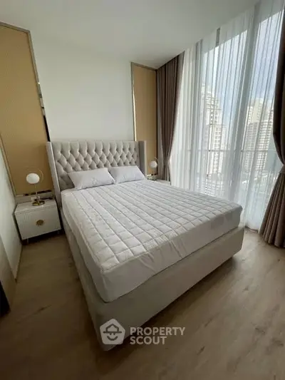 Luxurious bedroom with elegant decor and city view, featuring a plush bed and floor-to-ceiling windows.