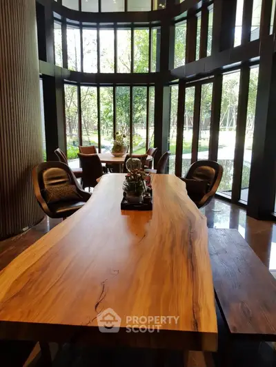 Luxurious modern dining area with large wooden table and garden view, perfect for elegant gatherings.