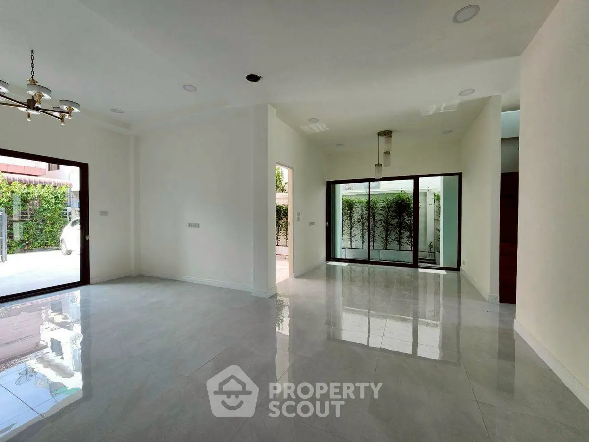 Spacious modern living room with large windows and elegant lighting, perfect for natural light and open living.
