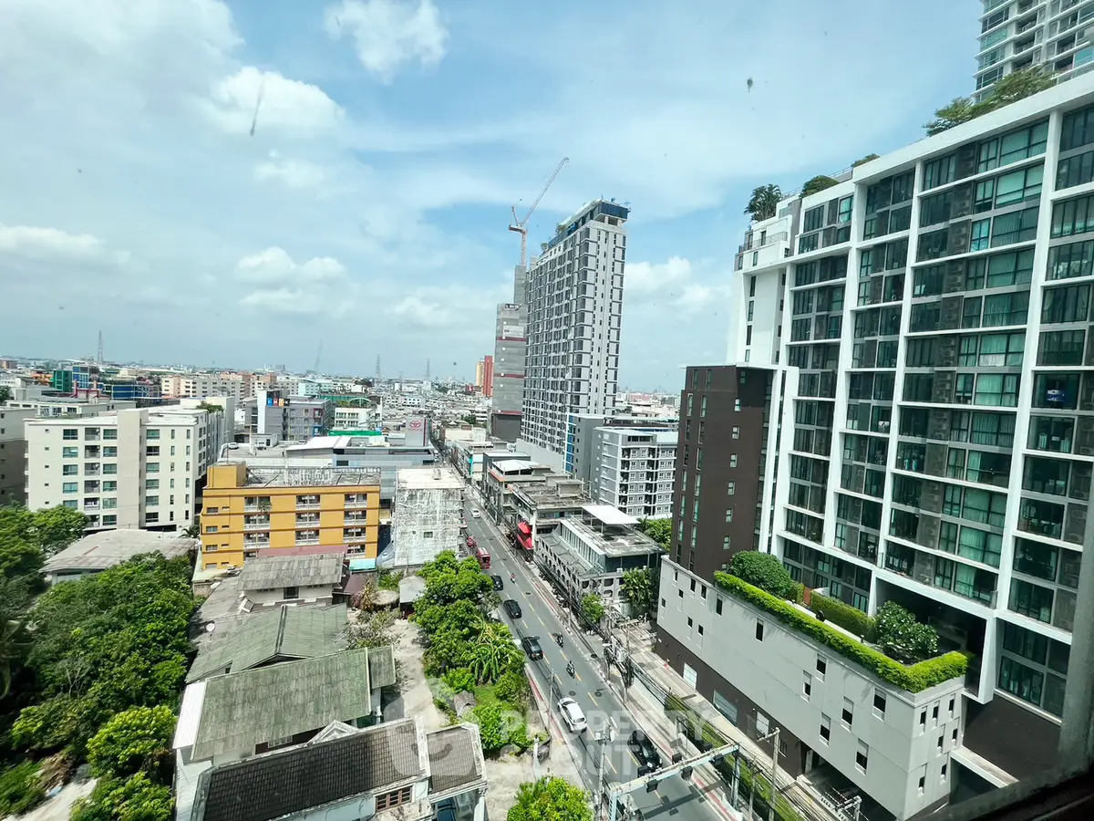 Stunning cityscape view from high-rise building with modern architecture and lush greenery.
