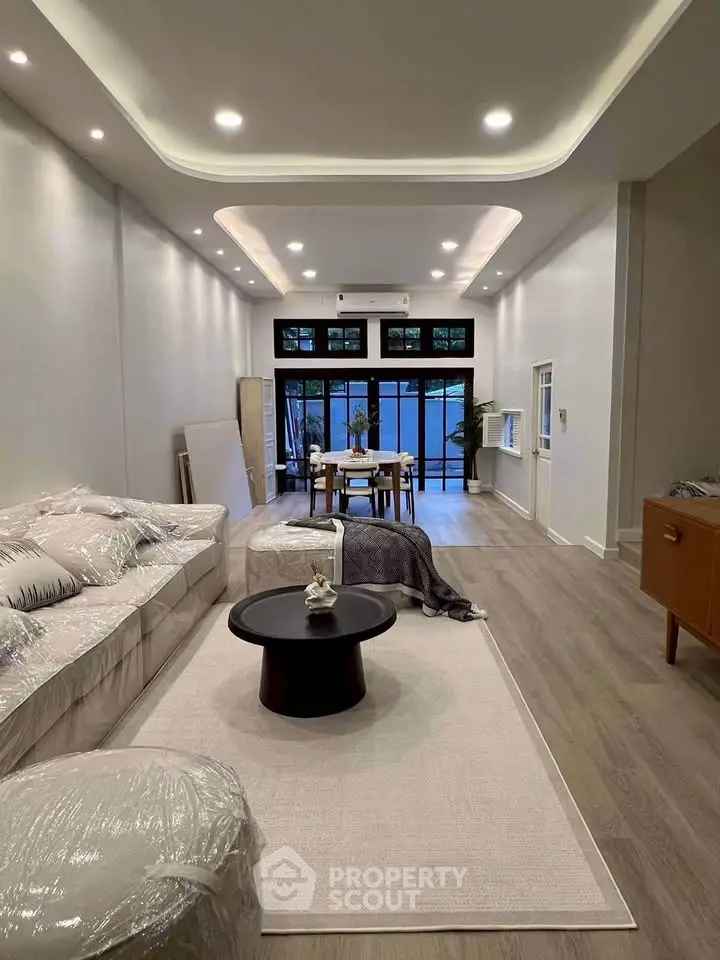 Spacious modern living room with elegant decor and large windows for natural light.