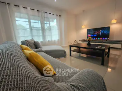 Spacious living room with modern decor and large TV, perfect for relaxation and entertainment.