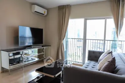 Spacious living room with modern furnishings, large windows, and balcony access offering an abundance of natural light and city views.