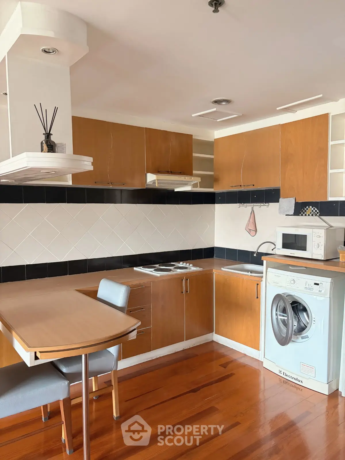 Modern kitchen with wooden cabinets, integrated appliances, and sleek dining area.