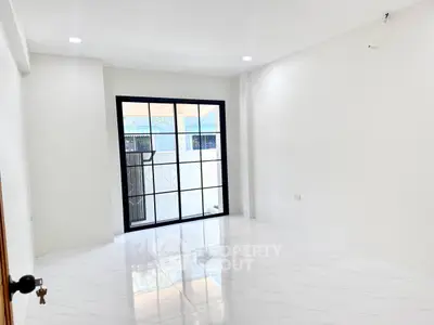 Bright and spacious interior with large windows and glossy white flooring