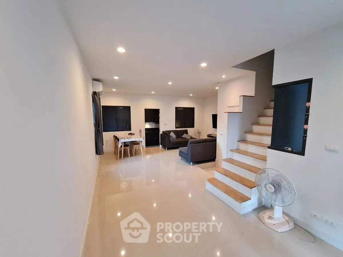 Spacious modern living room with sleek design and staircase