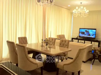 Elegant dining room with plush chairs, marble table, and chandelier lighting for luxurious living.