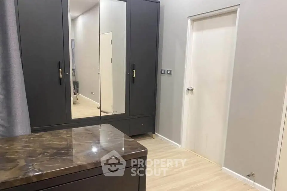 Modern bedroom with sleek wardrobe and marble-topped dresser