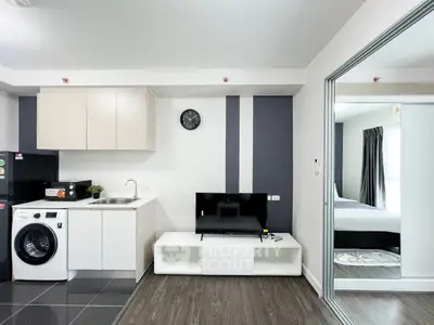 Modern studio apartment with sleek kitchen and cozy living area