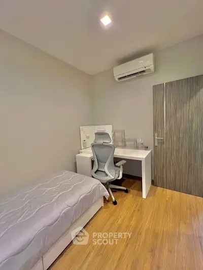 Cozy bedroom with study desk and air conditioning, perfect for students or remote work.