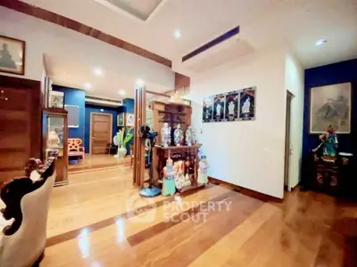 Spacious living area with wooden flooring and elegant decor in a modern home.