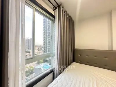 Modern bedroom with large window offering stunning city view in high-rise apartment.