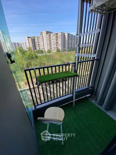 Charming balcony with artificial grass and city view, perfect for relaxation.