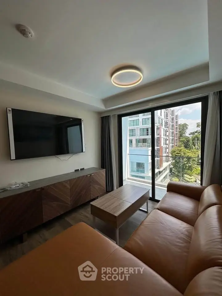 Modern living room with leather sofa and large window view