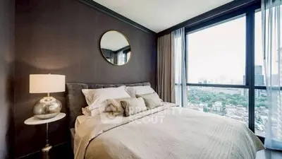 Luxurious bedroom with city view, elegant decor, and ample natural light.