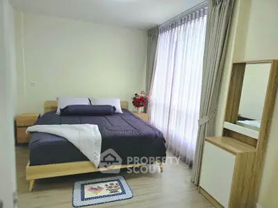 Cozy bedroom with modern decor and large window for natural light