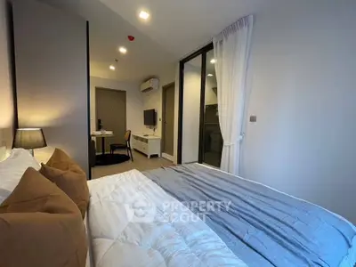 Modern bedroom with cozy bedding and stylish decor in a contemporary apartment.