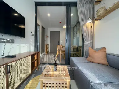 Modern living room with stylish decor and balcony view, featuring cozy seating and natural light.