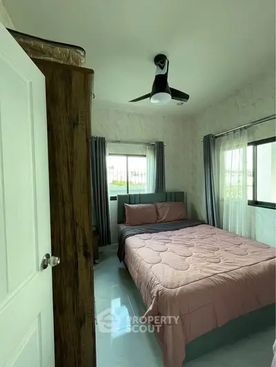 Cozy bedroom with modern ceiling fan and natural light
