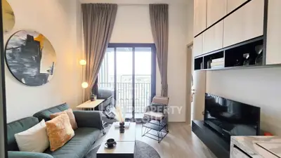 Modern living room with stylish decor and balcony view, featuring cozy seating and elegant lighting.