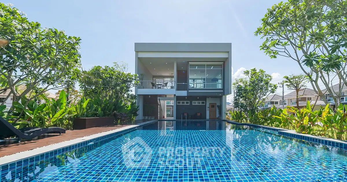 Luxurious modern home with stunning pool and lush garden view.