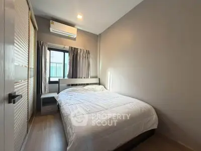 Cozy bedroom with modern design and ample natural light, featuring a comfortable bed and stylish decor.