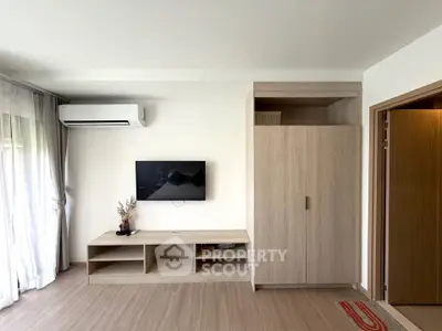 Modern living room with sleek TV setup and air conditioning, perfect for comfortable living.
