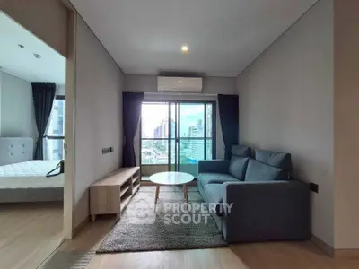 Modern living room with city view, featuring a cozy sofa and stylish decor in a high-rise apartment.