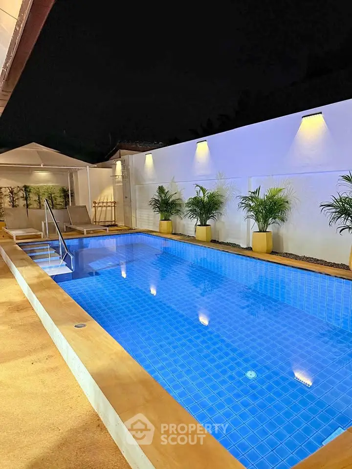 Luxurious night view of a modern swimming pool with ambient lighting and elegant poolside seating.