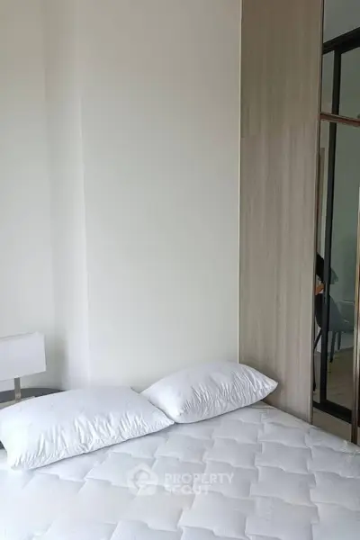 Modern bedroom with minimalist design and cozy bedding in a stylish apartment.