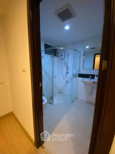 Modern bathroom with glass shower enclosure and sleek fixtures