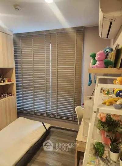 Cozy small bedroom with wooden flooring, built-in shelves, and air conditioning.