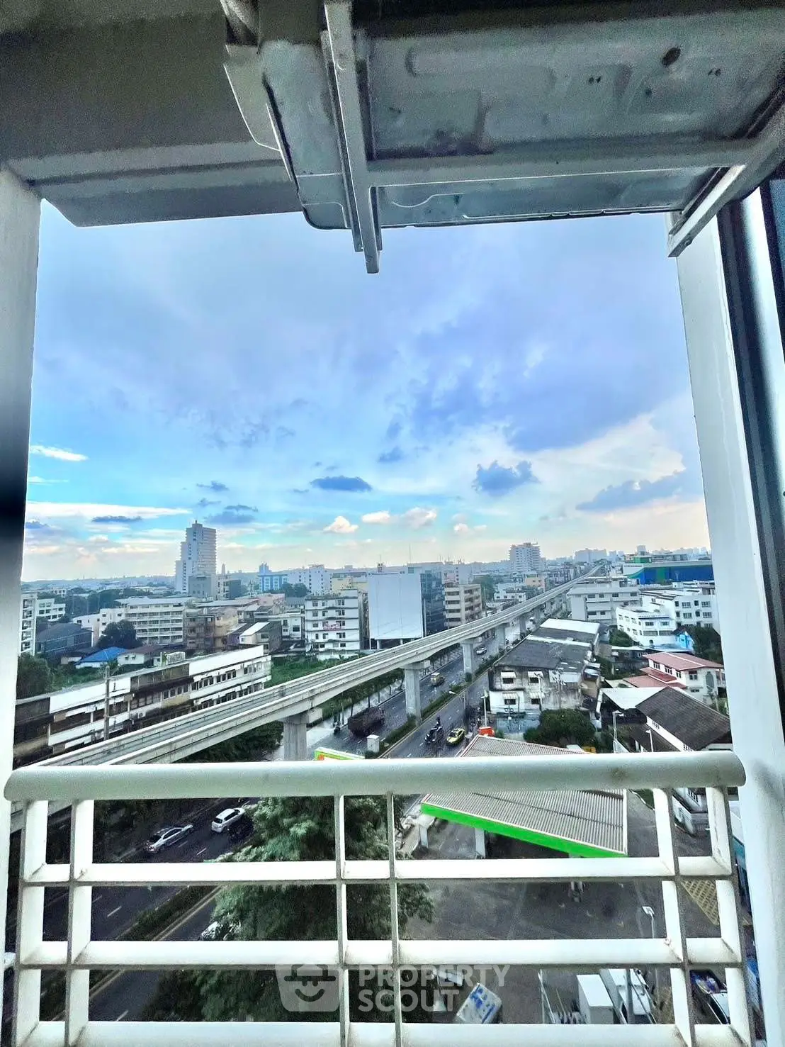 Stunning cityscape view from a high-rise balcony overlooking urban skyline and transportation.