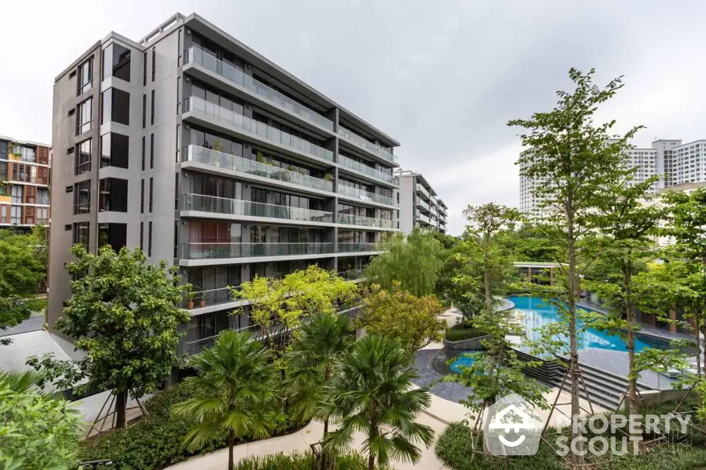 Modern apartment building with lush garden and pool view