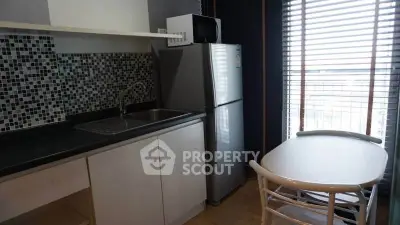 Modern kitchen with sleek design, featuring mosaic backsplash and stainless steel appliances.