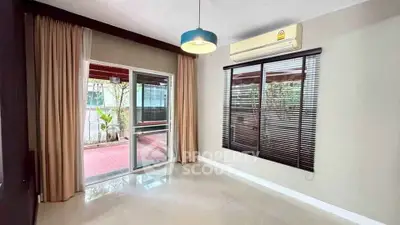 Spacious room with large window and balcony access, featuring modern lighting and air conditioning.