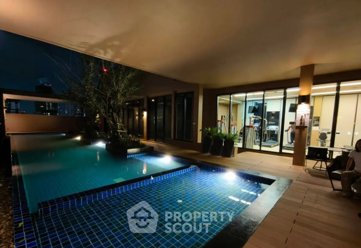 Luxurious indoor pool with modern gym facilities in a high-end residential complex.