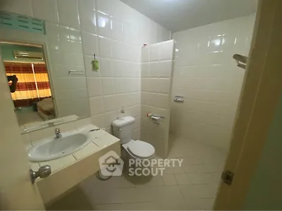 Spacious bathroom with modern fixtures and tiled walls in a cozy apartment.