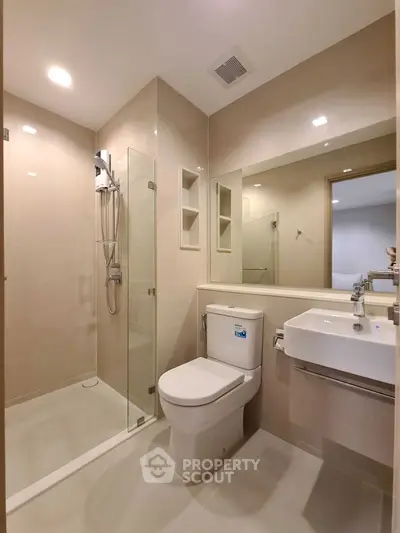 Modern bathroom with glass shower and sleek fixtures in a contemporary apartment.