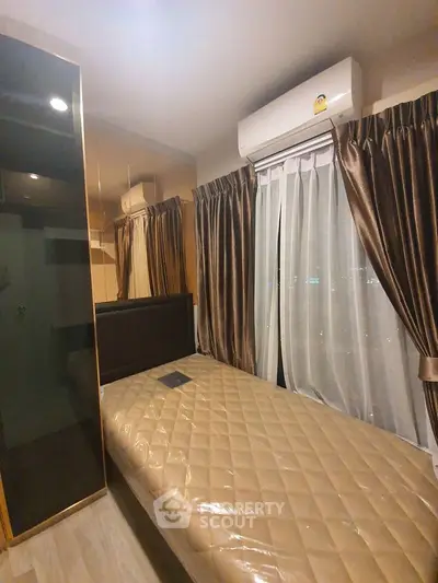Cozy bedroom with single bed and air conditioning, featuring elegant curtains and modern design.
