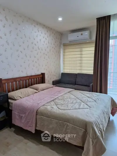 Cozy bedroom with stylish wallpaper, air conditioning, and a comfortable bed, perfect for relaxation.