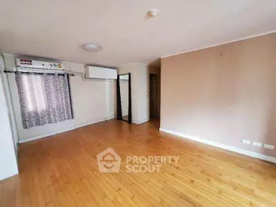 Spacious empty living room with wooden flooring and air conditioning